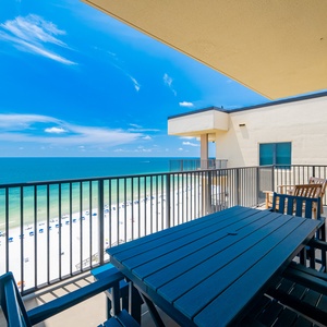 Enjoy stunning views from the spacious balcony, featuring comfortable seating and a vibrant blue sky above