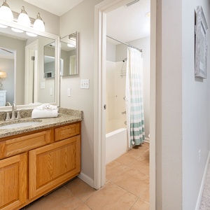 Spacious master bathroom features a granite countertop, ample storage, and a tub/shower combo
