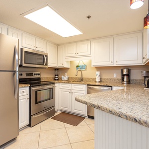 This kitchen features sleek stainless appliances, granite countertops, and a convenient breakfast bar