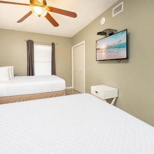 Sleep peacefully in this inviting guest bedroom with two comfortable queen beds, a TV, and a restful ambiance