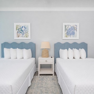 Rest in this inviting guest room featuring two queens with soft pillows and stunning beach views