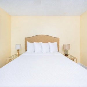 White linens soften the queen bed in the master suite creating a calm space to rest after a day outdoors