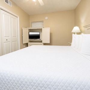Relax in this inviting bedroom featuring a king bed, a TV for entertainment, and soft lighting for a restful atmosphere