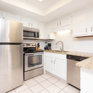 This kitchen features stainless appliances, granite countertops, and a coffee maker, perfect for your culinary adventures