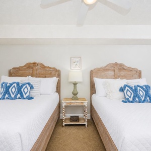 Rest in the cozy guest bedroom featuring two double beds with decorative pillows