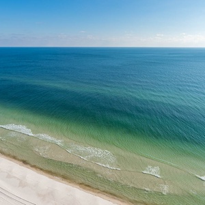 Gaze at the tranquil waters blending shades of blue and green, inviting you to relax and enjoy the serene atmosphere