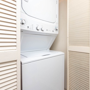 This laundry area features a stacked washer and dryer behind louvered doors for convenient in-unit laundry during your stay