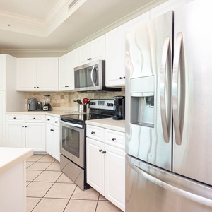 Prepare meals in this kitchen with elegant cabinetry, stainless appliances, and spacious countertops