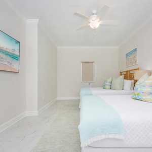 Unwind in this playful guest bedroom featuring two queen beds and a wall-mounted TV