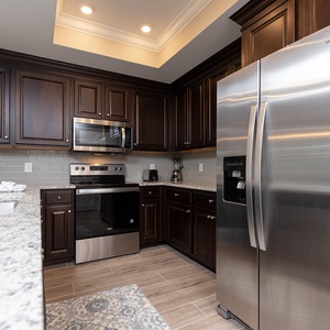 Create memorable meals in the kitchen, surrounded by dark cabinetry and sleek, stainless appliances