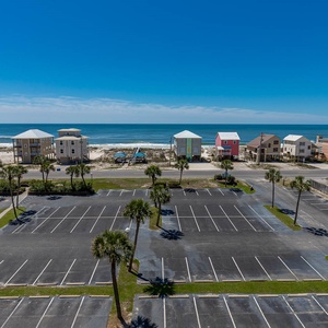 Enjoy a stunning beach view from this bright space, featuring palm trees and colorful beach houses lining the shore