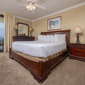 Relax in the master bedroom featuring a large king bed, tasteful decor, and easy access to the balcony with coastal views