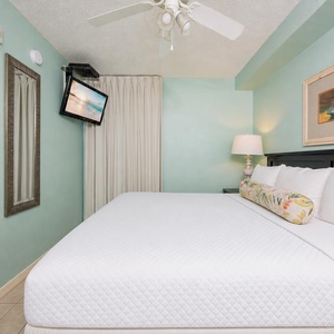 Fluffy pillows invite you to relax in the king suite for a calm movie night after a fun day at the beach