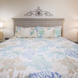 Tranquil master suite featuring a plush king bed, decorative pillows, and soft lighting for a restful stay