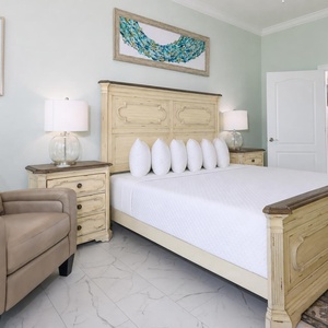 Unwind in the master suite featuring a plush king bed with fluffy pillows and elegant master bath