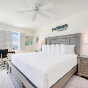 Your master suite with a king bed welcomes you to unwind while gazing through shuttered windows at the water
