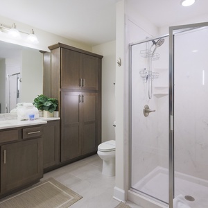 Experience a refreshing shower in this guest bath with elegant cabinetry and spacious walk-in design