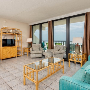 This soothing living area features comfortable seating and stunning beach views through large windows, perfect for relaxation