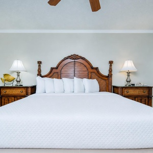 Experience restful nights in this spacious master bedroom featuring a king bed, elegant decor, and charming accents