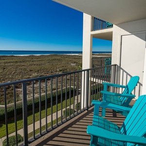 Balcony overlooks the beach and tranquil gulf waters, inviting relaxation in a serene coastal setting