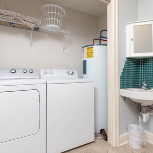 Utilize the convenient laundry area featuring a washer, dryer, and half bath for effortless cleaning during your stay