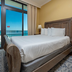 Relax in the queen bed as you enjoy beautiful coastal views from the balcony in this guest suite