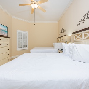 Inviting guest bedroom featuring two comfortable beds, a TV, and stylish decor for a relaxing stay