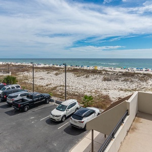 This view showcases a beautiful beachfront with sandy dunes and colorful umbrellas, perfect for relaxation and fun