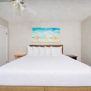 Studio featuring a large king bed, colorful artwork, and cozy decor for a relaxing getaway