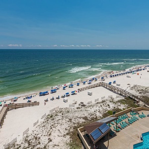 Coastal view with vibrant beach umbrellas and a sparkling pool, perfect for a relaxing getaway