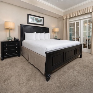 The master bedroom features a plush king bed, stylish black furniture, and elegant decor, creating a serene retreat