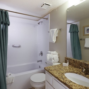 Guest bathroom featuring a granite countertop, a tub/shower combo, and fresh towels for a comfortable stay