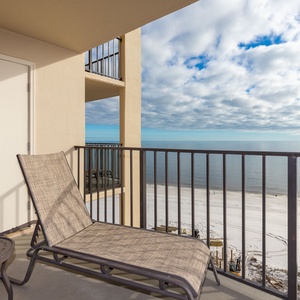 Relax on the balcony lounge chair, enjoying serene views of the serene beach and tranquil waters