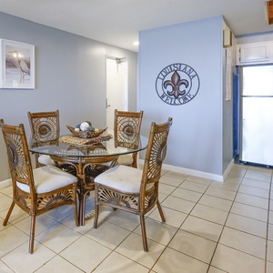 This dining area features a glass-top table surrounded by stylish wicker chairs, perfect for enjoying meals together