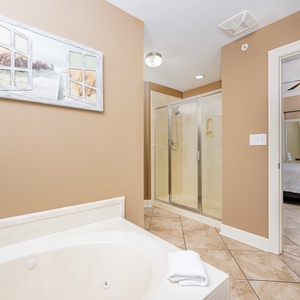 The master bath features a relaxing jetted tub and a spacious walk-in shower, with a view of the inviting bedroom beyond