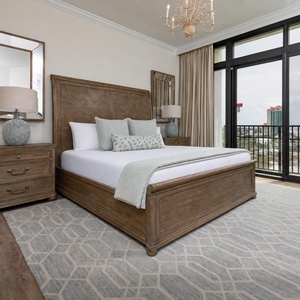 The master bedroom features a stunning view, king bed, a stylish chandelier, and elegant wooden furnishings