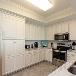 Prepare meals in this kitchen with elegant cabinetry, stainless appliances, and sleek countertops