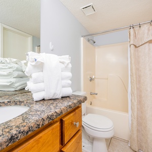 Relax in the soothing bath, surrounded by fresh towels and light, creating a tranquil retreat after beach adventures