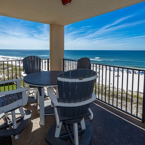Enjoy a relaxing moment on the balcony with a round table and chairs, overlooking the beach and azure waters