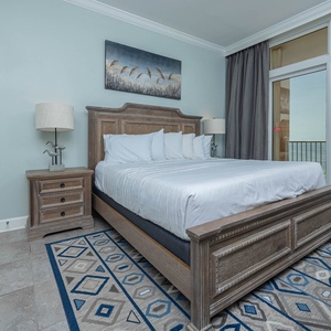 Inviting master bedroom featuring a king bed, stylish decor, and beachfront balcony access