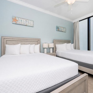 Experience restful nights in this inviting guest bedroom with two queen beds and calming beach decor