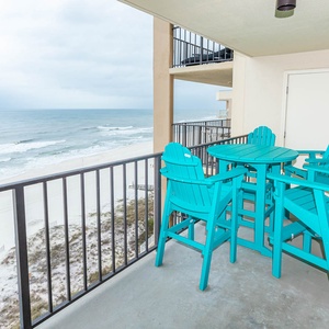 Enjoy the vibrant turquoise seating on the balcony, perfect for taking in the beautiful beach views