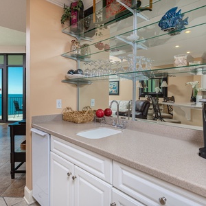 Craft a refreshing drink at the sleek wet bar, then unwind in the inviting living area with stunning coastal views