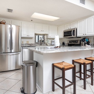 Gather around the spacious kitchen bar, featuring sleek countertops and seating for casual dining or morning coffee