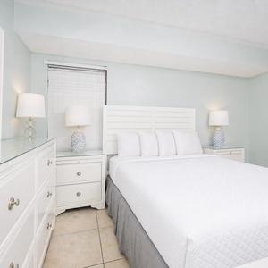 This inviting bedroom features a comfortable bed, stylish lamps, and a serene color palette for a restful stay