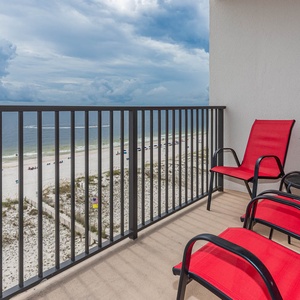 This balcony features vibrant red chairs and offers a stunning beachfront view, perfect for relaxation and enjoyment