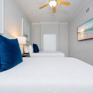 Unwind with a show or good movie in this guest bedroom with two queens, and enjoy soothing coastal decor