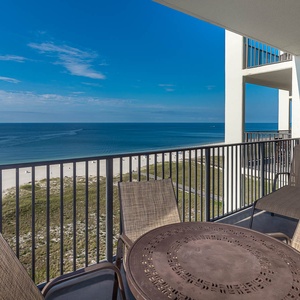Balcony seating offers a serene view of the white sand beach and tranquil gulf waters under a clear blue sky