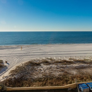 Tranquil beach with soft white sand and gentle waves under a clear blue sky