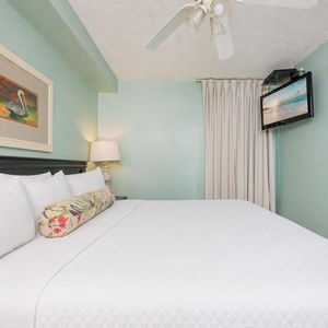 Fluffy pillows invite you to relax in the king suite for a calm movie night after a fun day at the beach